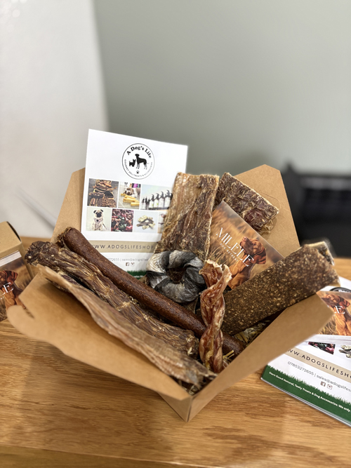 A Dog's Life natural treats box filled with various chews
